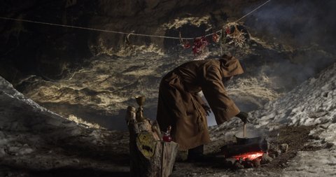 Senior hermit preparing magic potion in cave