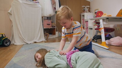 Little boy offends girl on the floor