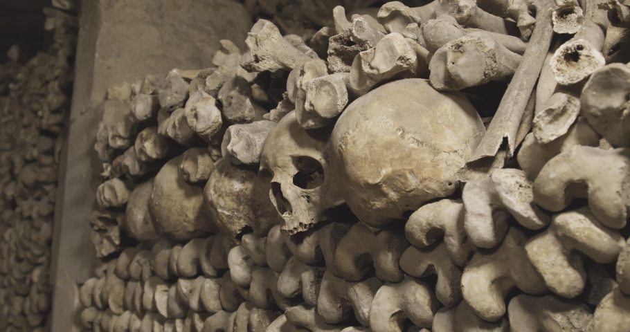 Close-up shot of human skulls and bones in the underground of Paris | Shutterstock HD Video #1085793320
