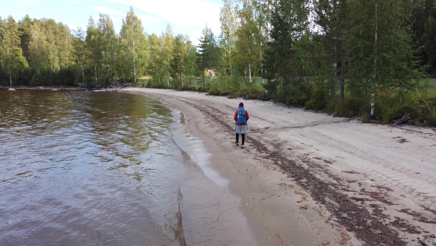 Close-up of a traveller walking along the beach in Koli National Park in eastern Finland, continuing his quest for adventure. Discovering the pristine Scandinavian wilderness. 4k drone video