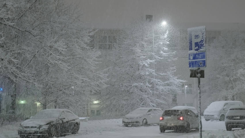 The strong snowfall in the night in Helsinki, Finland. Snow-covered city street.