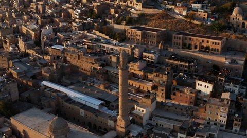 Minaret Of The Grand Mosque Of Mardin In Turkey At Sunset With Overview Of Buildings In Background. aerial