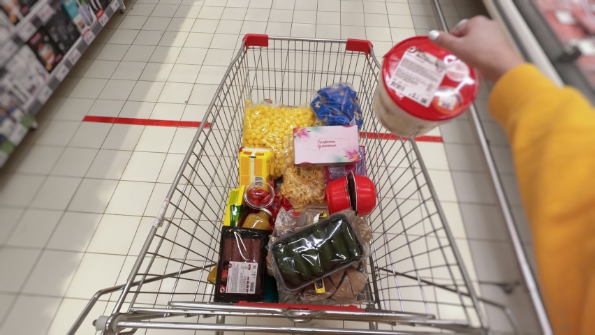 First-person view of puttig groceries in shopping cart