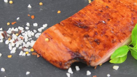 Smoked bacon, basil and seasonings on rotating slate tray. Bacon, basil and seasonings on a rotating slate plate. Macro