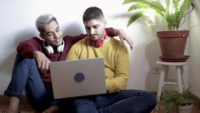 Gay men couple having fun using laptop computer at home - Lgbt love concept