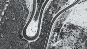 Travel journey and vacation concept High angle aerial view drone video on the curved serpentine road car driving in mountain range with white snow in winter day near Knjazevac in Serbia