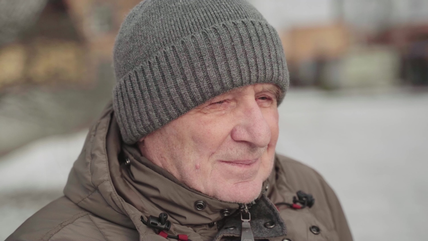 Caucasian white elderly man close up portrait on winter sunny day. Trekking active lifestyle male on retirement. Handheld video | Shutterstock HD Video #1085807723