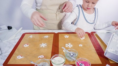Time lapse. Step by step. Little girl helping to make a homemade lollipops with fondant snowflakes.