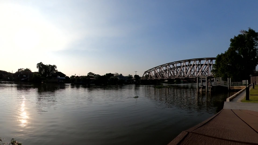 time lapse of sunset with old iron bridge water front and pier