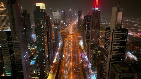 Aerial drone view at night of futuristic skyscraper buildings over Sheikh Zayed highway - Dubai - Dec 2021