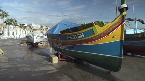 Marsaxlokk , Malta - 12 10 2021: Traditional Fishing Boat Decorated with Osiris Eyes in the Harbour of the Fishing Village of Marsaxlokk in Malta Island