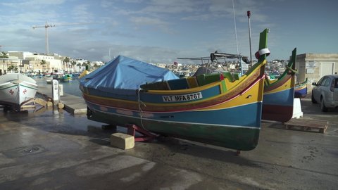 Marsaxlokk , Malta - 12 10 2021: Traditional Fishing Boat Decorated with Osiris Eyes in the Harbour of the Fishing Village of Marsaxlokk in Malta