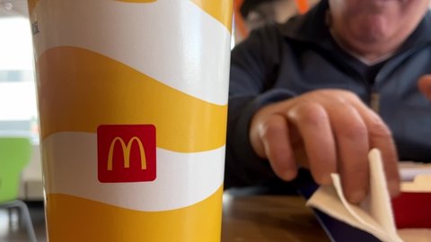 Belgrade, Serbia 01.12.2021. Fat male person eating McDonald's Big Mac. Unhealthy lifestyle 
