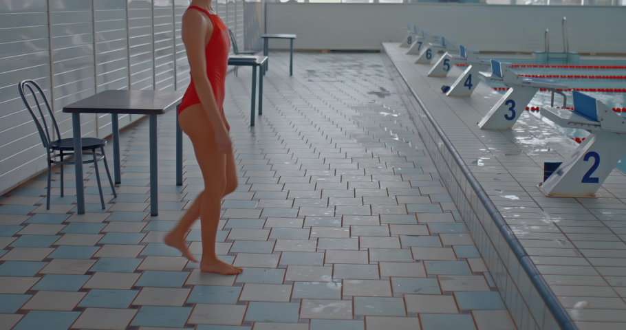 Woman athlete prepares for the start, stands on a diving board. Woman swimmer dives into the water from a water springboard, winner in the swimming championship. 4k, ProRes Royalty-Free Stock Footage #1085829422