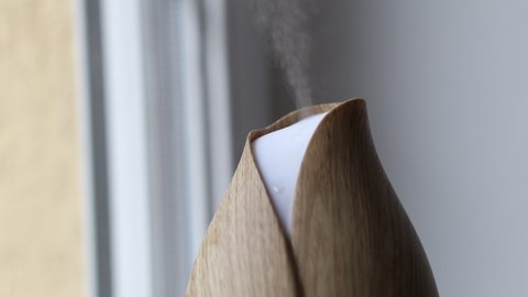 Close-up of Modern Air Humidification Indoors. Wooden Aroma Diffuser at Home.