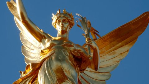 LONDON, circa 2022 - Close-up shot of the Gilded Winged Victory at the top of the Victoria Memorial, opposite Buckingham Palace in London, England, UK
