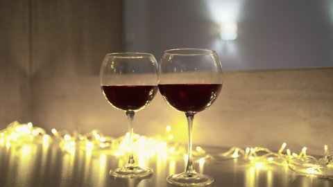 two glasses of wine, young sexy couple in bed hugging and kissing. Anniversary celebration concept or for all lovers.