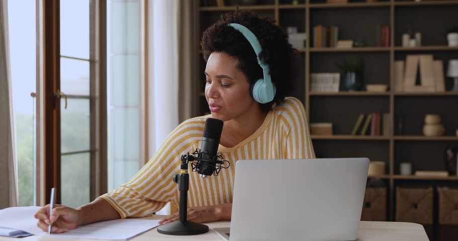Educational webinar, streaming communication, modern tech, internet connection concept. Attractive African woman in headphones sit at desk talk into microphone take notes, take part in virtual meeting Royalty-Free Stock Footage #1085842187