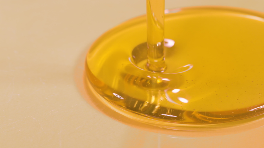 SLOW MOTION, MACRO, DOF: Delicious organic extra virgin olive oil flows into a deep dish. Shot of unrefined cold pressed walnut oil getting poured into a large container. Natural beauty product. Royalty-Free Stock Footage #1085847722