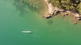 Aerial drone bird's eye view video of two sport canoe operated by team of young men and women 