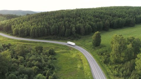 Panorama with truck driving on highway in summer. Action. Beautiful summer landscape with green trees and truck driving along highway. Truck is driving on country highway on summer day Video de stock