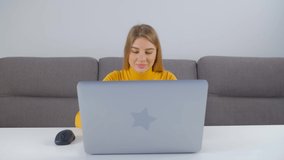Beautiful white woman working on laptop computer. Professional freelancer person doing distant work from home during lockdown. Blonde Caucasian female typing on notebook pc in 4k stock video clip