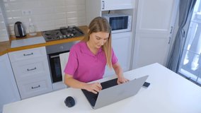 Online student typing on laptop computer at home on lockdown. Young blonde woman working on notebook pc in 4k stock video. Freelancer female doing distant work with fast internet connection