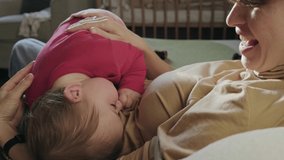 Video with a mother caresses the baby as he tries to fall asleep in her arms. Baby care.