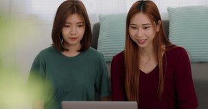 Happy Asian college student casual wear using computer working call video conference with group mate in living room at home.