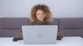 Young adult woman typing on laptop keyboard. Distant freelance work concept in 4k video. White female working on modern notebook pc at home during lockdown. Person using computer for online education