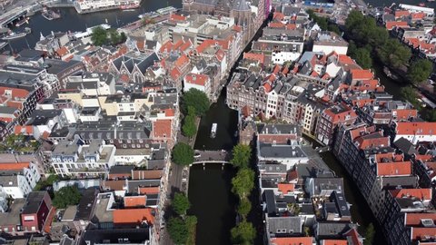 Aerial drone view of Amsterdam Red Light District moving over on of the canals towards ij lake in city center famous tourist attraction and destination in the Netherlands Europe 4k quality
