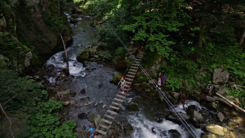 people at extreme park attraction above mountains river summer time