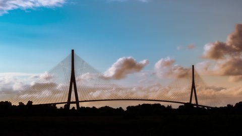 Silhouette of the cable bridge at sunset in Le Havre, Normandy, France. Time lapse