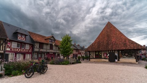 Beuvron en Auge, France - August 3, 2021: Square in a  famous tourist village of Beuvron-en-Auge, one of the most beautiful villages in Normandy, France.   Time lapse.