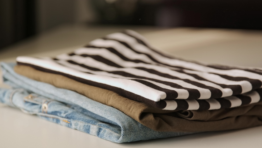 Stack clothing for sorting and baggage packing. Clothes for donation or shopping concept. Folding clothing storage and minimalism things. Environmentally Friendly Consumption. Royalty-Free Stock Footage #1085873033