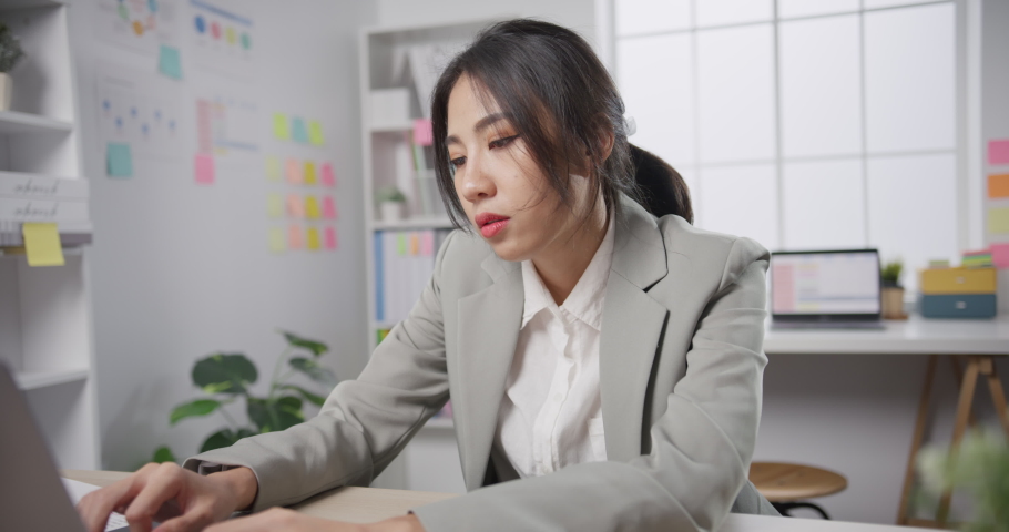 Young Asian businesswoman sit on desk with laptop overworked tired burnout syndrome at office. Exhausted lady with sleeply eye at workplace, Girl not enjoy unhappy with work, Work mental health. Royalty-Free Stock Footage #1085873120
