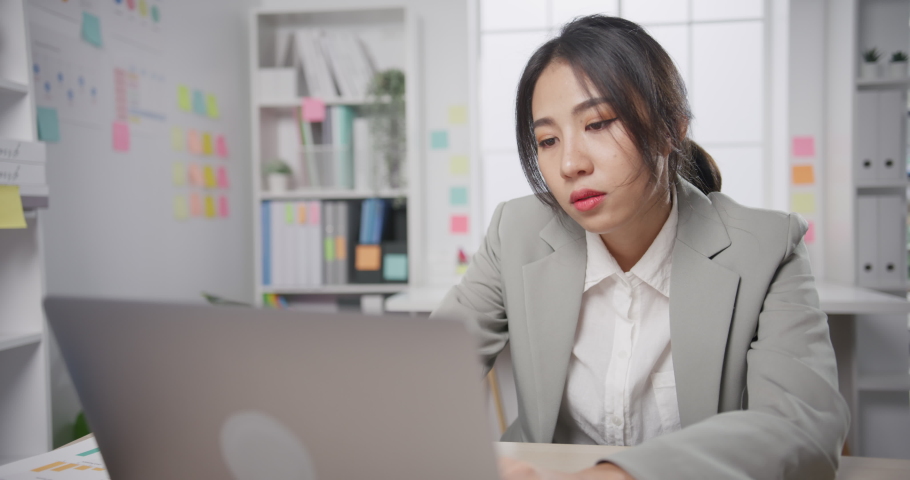 Young Asian businesswoman sit on desk with laptop overworked tired burnout syndrome at office. Exhausted lady with sleeply eye at workplace, Girl not enjoy unhappy with work, Work mental health. Royalty-Free Stock Footage #1085873120