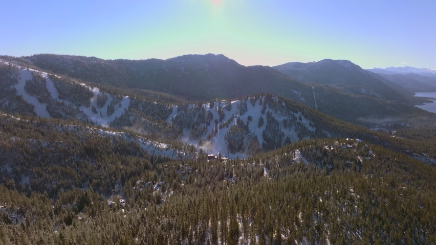 Aerial of mountains in Lake Tahoe with boom and twist down to road below.