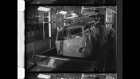 1950 Wolfsburg, Germany. Volkswagen automotive factory. VW Bus on production line. The entire metal frame of transporter dipped in automotive paint. 4K Overscan of Archival 16mm Newsreel Film Print