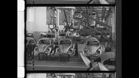 1950 Wolfsburg, Germany. Volkswagen automotive factory. The Body Shell of The People's Car, a VW Beetle on the assembly line at automotive factory. 4K Overscan of Archival 16mm Newsreel Film Print 