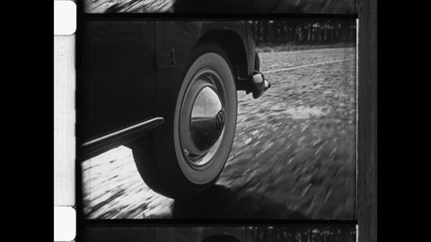 1950 West Germany. Close Up of Volkswagen car tire on cobblestone street, a symbol of the economic miracle in post war Germany. 4K Overscan of vintage archival 16mm newsreel film print