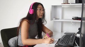 Student girl studying online with headphones and computer laptop. mixed race asian chinese model.