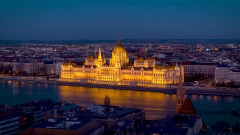 Elevated day to night time lapse view of the Hungarian Parliament in Budapest with traffic at the River Danube