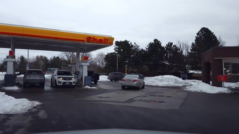 Toronto, Ontario, Canada - January 22nd, 2022. Driver Point of View Driving Into Gas Fuel Station in Winter. Drive Car Vehicle Toward Gasoline Petrol Convenience Store.
