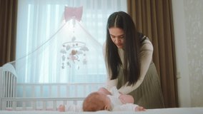 Beautiful young mother change her baby daughter very carefully in the bedroom she change the diaper concept of nursing morning. 4k