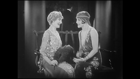CIRCA 1925 - In this silent film, a flapper flatters a socialite at a party and finds herself surrounded by interested older women.