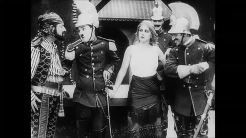 CIRCA 1915 - In this silent comedy, a soldier (Charlie Chaplin) comically sword fights his rival with a dagger and a saber.