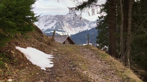 Walking towards wooden log cabin in the Swiss mountain side in first person view