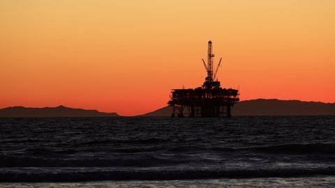 The sun setting behind an offshore oil platform off the coast of California