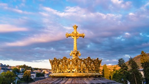 The historic gilded crown with a cross in front of the Basilica of the Apparitions of Mary in Lourdes, France